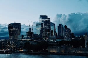 Arranha-céus modernos iluminados ao entardecer, representando o mercado financeiro
